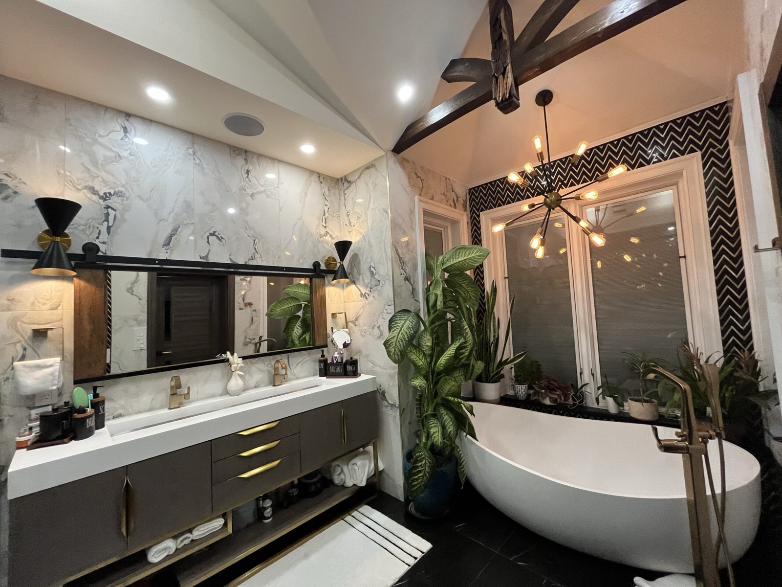 Residential bathroom with marble wall finish and freestanding tub